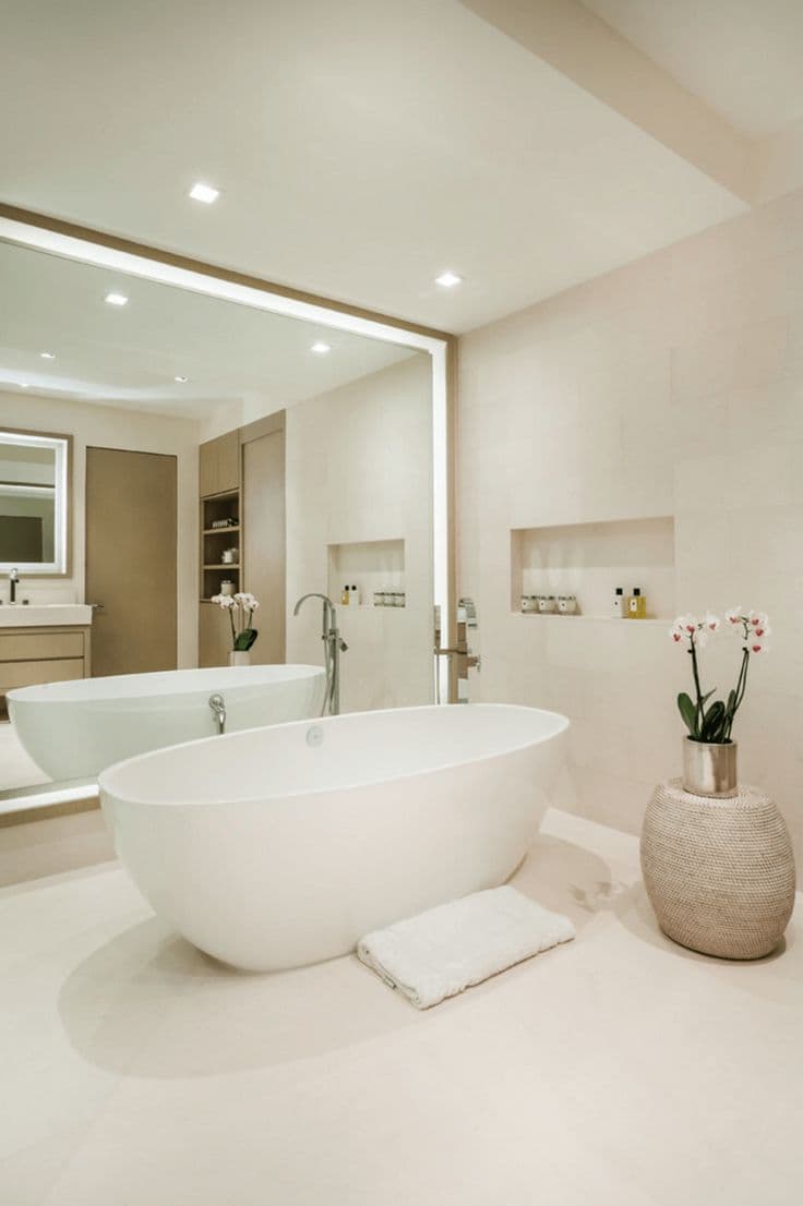 a bath room with a tub a sink and a mirror on the wall next to a table, classique, tadelakt