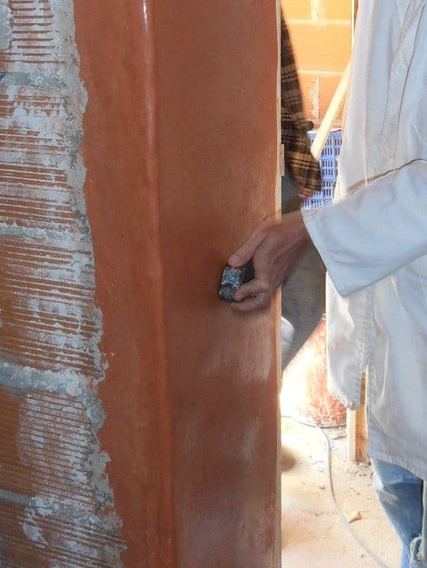 a man in white jacket opening a brick wall, classique, tadelakt