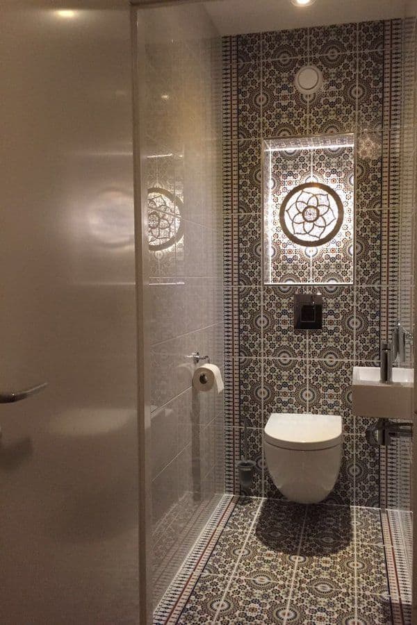 a bathroom with a toilet, sink and shower stall is seen through the glass door, classique, tadelakt