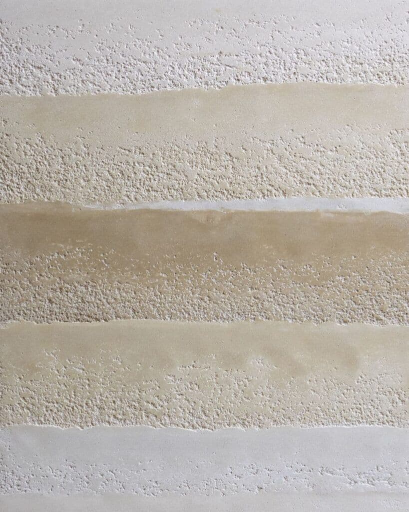 the wall is lined with white and beige striped paint strips that are painted in different colors, classique, tadelakt